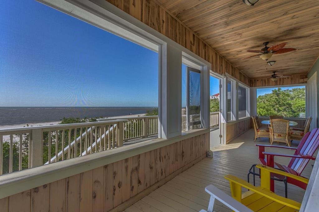 a porch with rocking chairs and a view of the ocean at Island Idyl by Pristine Properties Vacation Rentals in Indian Pass