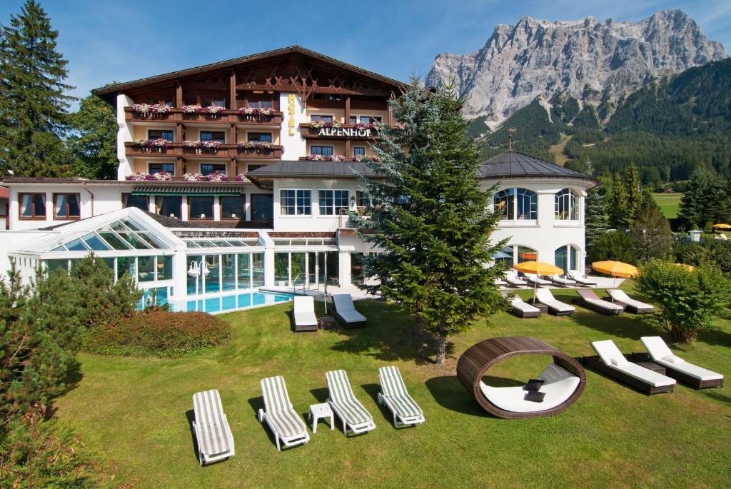 a hotel with a bunch of lounge chairs in the yard at Wellness & Sporthotel Alpenhof in Ehrwald