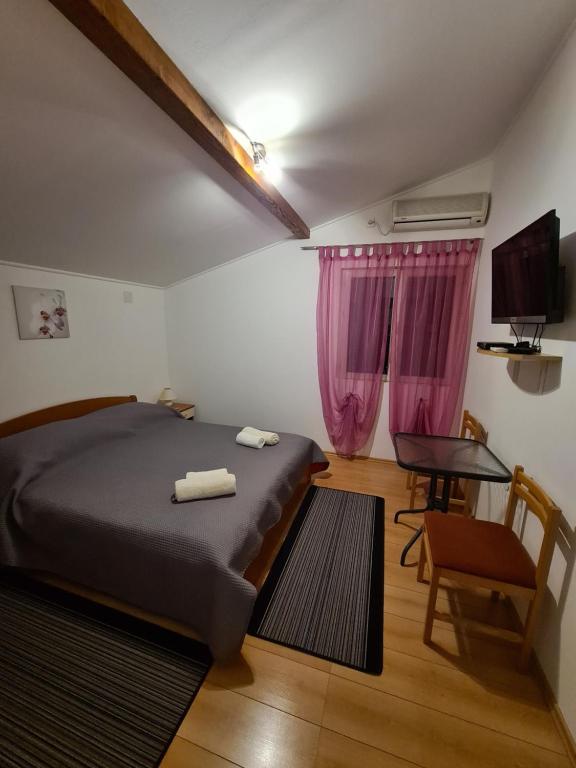 ein Schlafzimmer mit einem Bett, einem Tisch und einem Stuhl in der Unterkunft Camp Krka in Lozovac