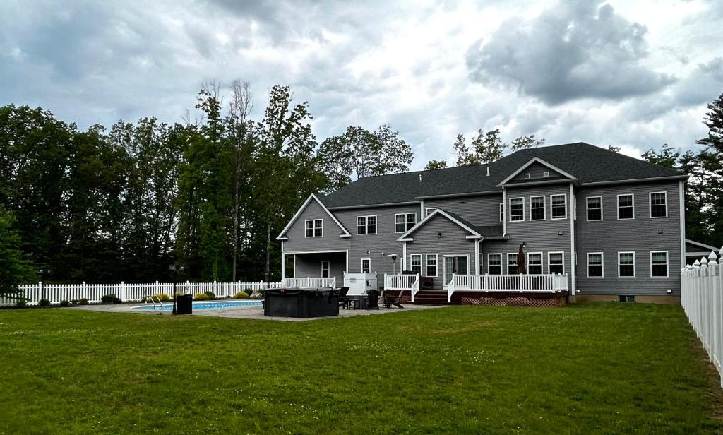 a large gray house with a pool in the yard at 9 Bedroom Saratoga Retreat, Heated Pool, HotTub On 10 Acres By Track, Town, SPAC, Hiking, Ski, Golf, & Saratoga Lake in Saratoga Springs