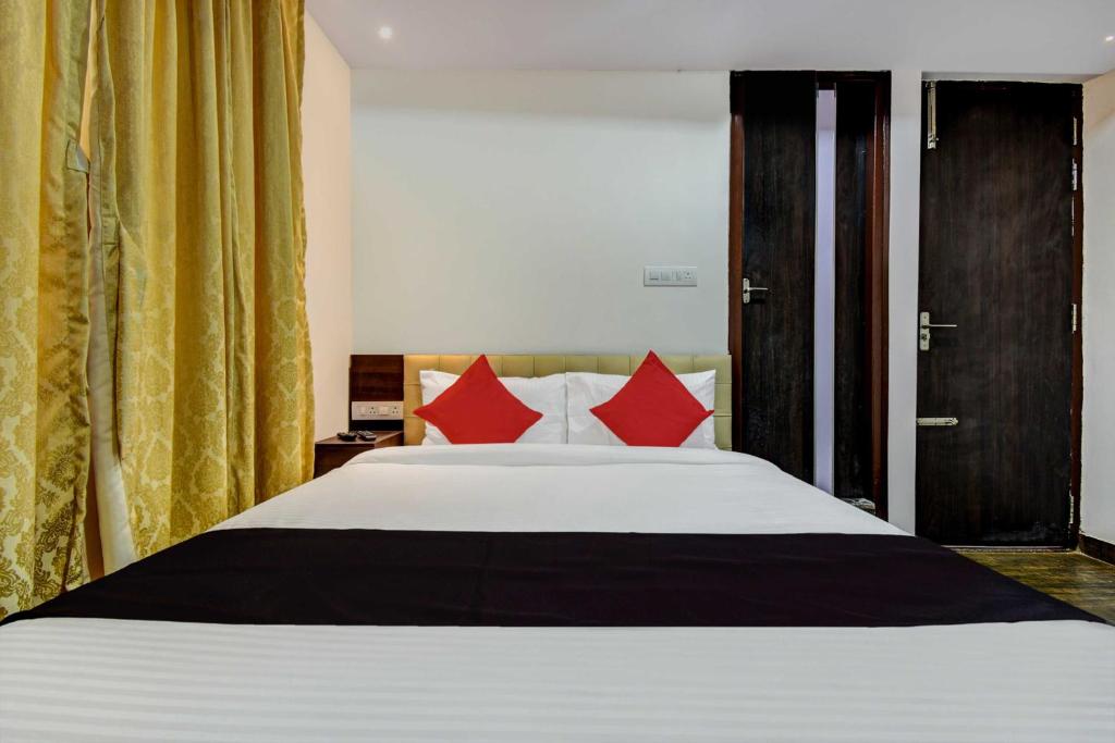 a bedroom with a large bed with red pillows at Collection O 73565 J J Global Exotics Stays in Bangalore