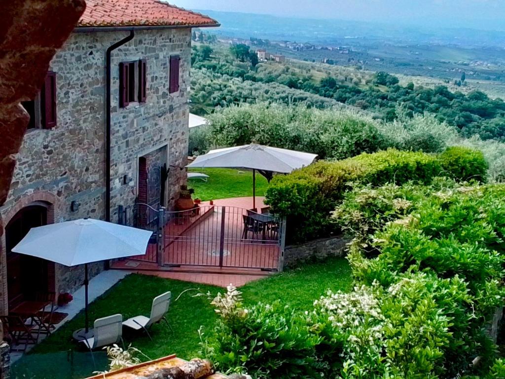 une maison dotée d'un balcon avec des parasols et des chaises dans l'établissement Casa della Noce, à Vinci