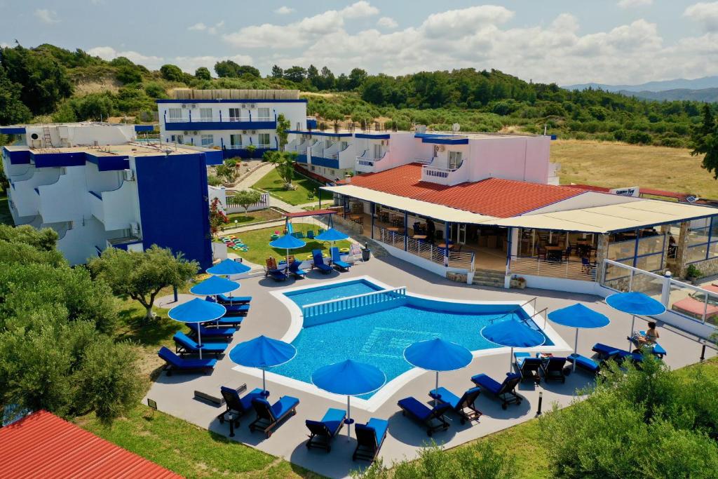 widok z góry na ośrodek z basenem i niebieskimi parasolami w obiekcie Summer View w mieście Theologos