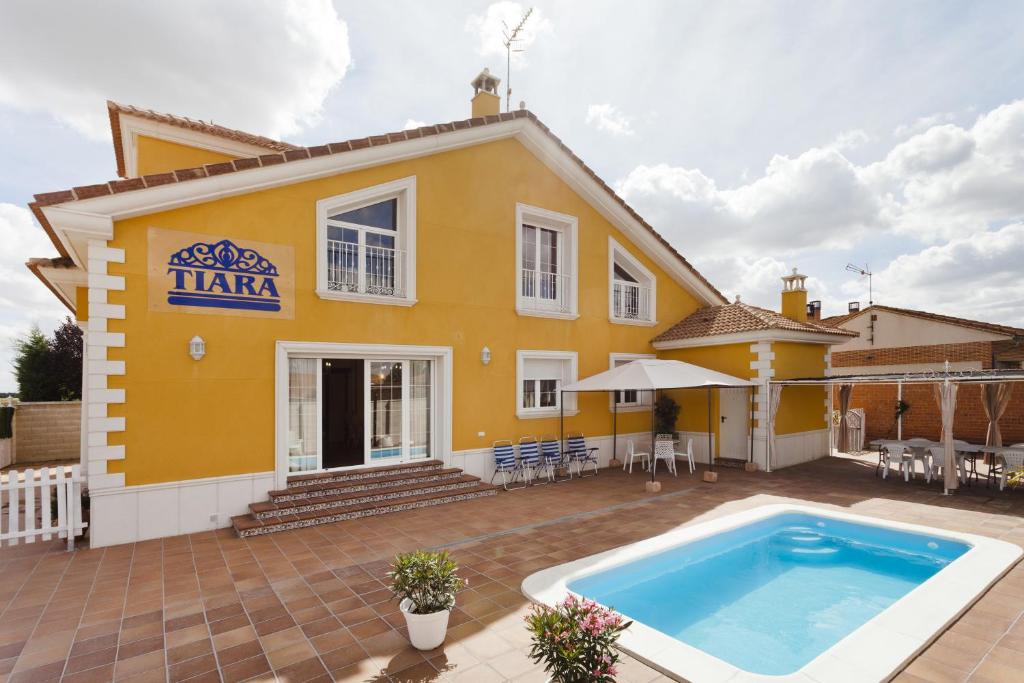 a yellow house with a swimming pool in front of it at Tiara Vacaciones in Nava de la Asunción