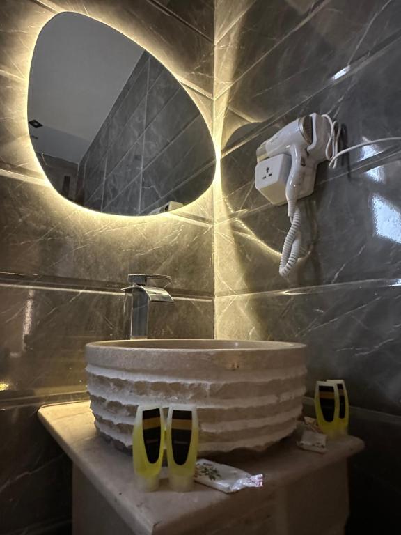 a bathroom with a stone sink and a mirror at Crowne Pyramids view inn in Cairo