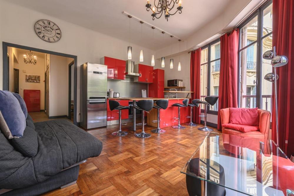 une cuisine avec des placards rouges et une table en verre dans l'établissement Charmant appt 3 chambes au coeur de Nice-5 mns plages, à Nice