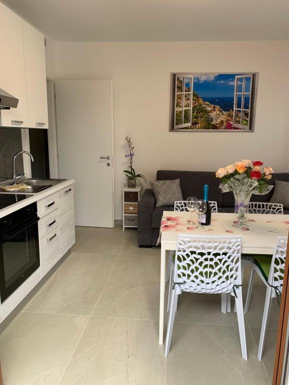 a kitchen and living room with a table and a couch at Appartamenti Estera 2 in Malcesine