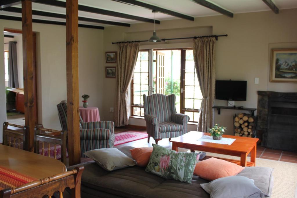 a living room with a couch and a table at Cottage Suikerbekkie in Dullstroom