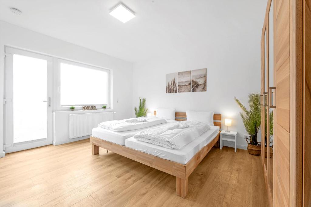 a white bedroom with a large bed in it at Auszeit Borkum in Borkum