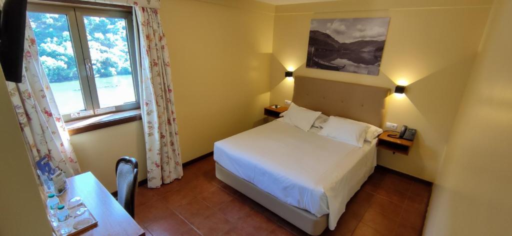 - une chambre avec un lit blanc et une fenêtre dans l'établissement Hotel Casa do Tua, à Foz Tua
