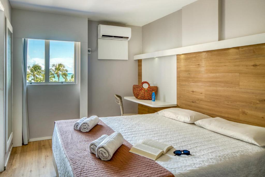 - une chambre avec un lit et des serviettes dans l'établissement Hotel Costamar Ponta Verde, à Maceió