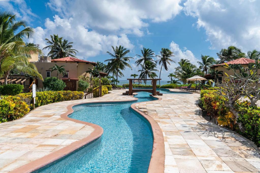 a pool at a resort with palm trees at Villa Serenity in San Pedro