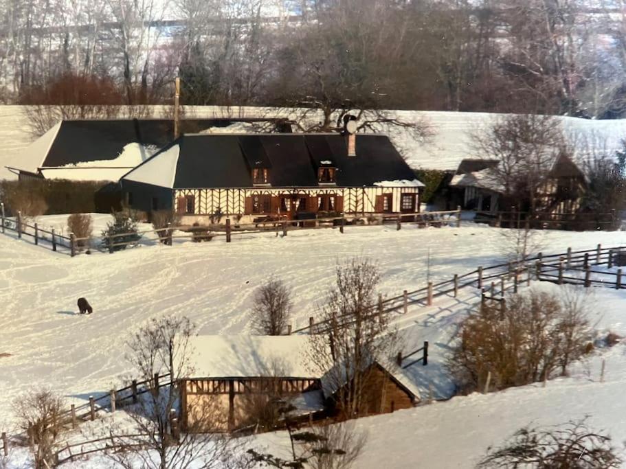 a large house in a snow covered field at Maison au calme a la campagne in Hermival-les-Vaux