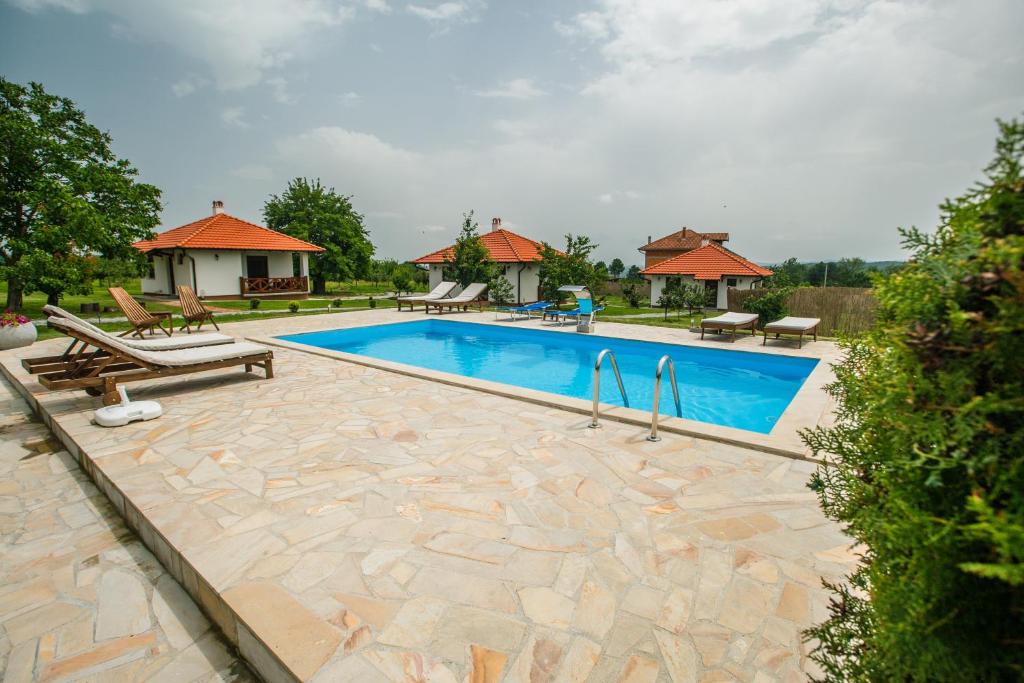 een zwembad met tuinmeubilair bij Apartmani Čalane in Topola