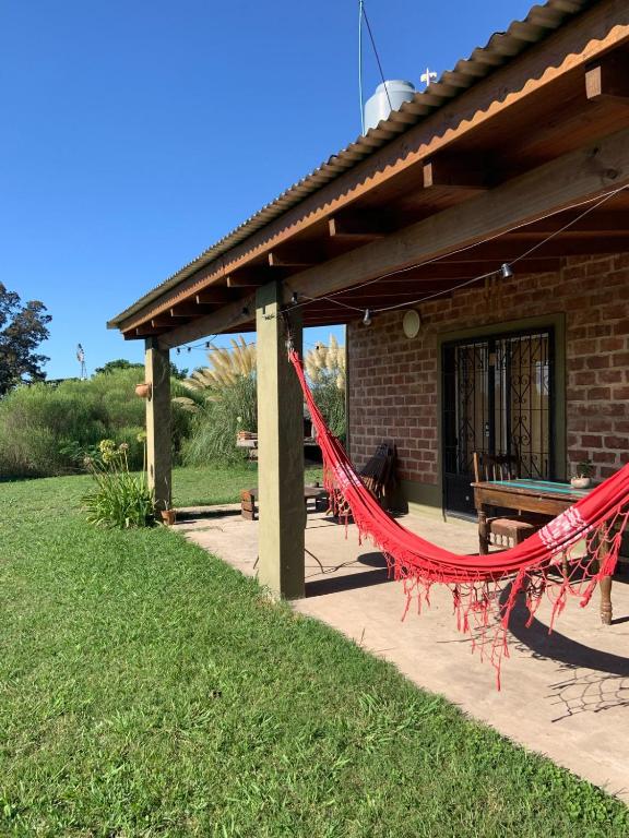 a patio with a red hammock in front of a building at Casa rústica in San Pedro