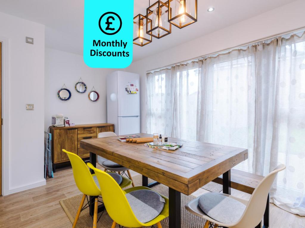 uma sala de jantar com uma mesa de madeira e cadeiras amarelas em Cozy 1BR Home in Vibrant Manchester Free Parking - Fast Internet em Manchester