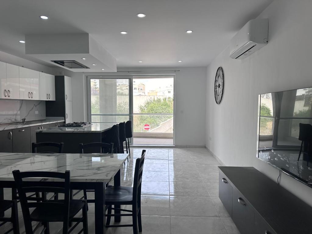 a kitchen and dining room with a table and chairs at Mediterranean Nest in Is-Swieqi