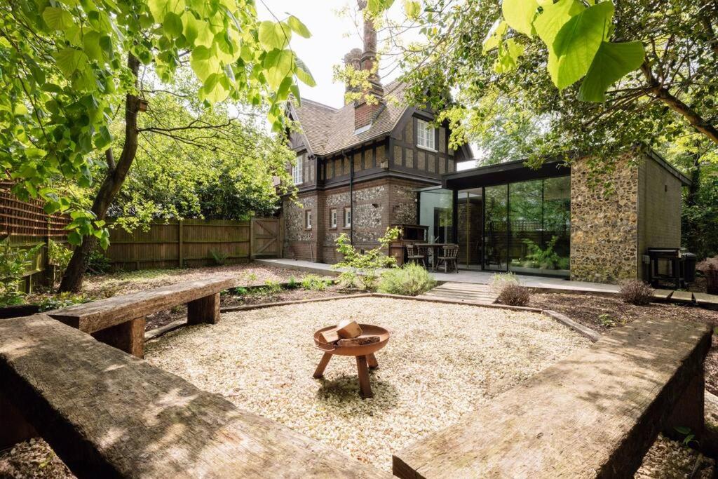 a garden with benches and a table in front of a building at Parea Living - Spacious North London House with Big Garden in London