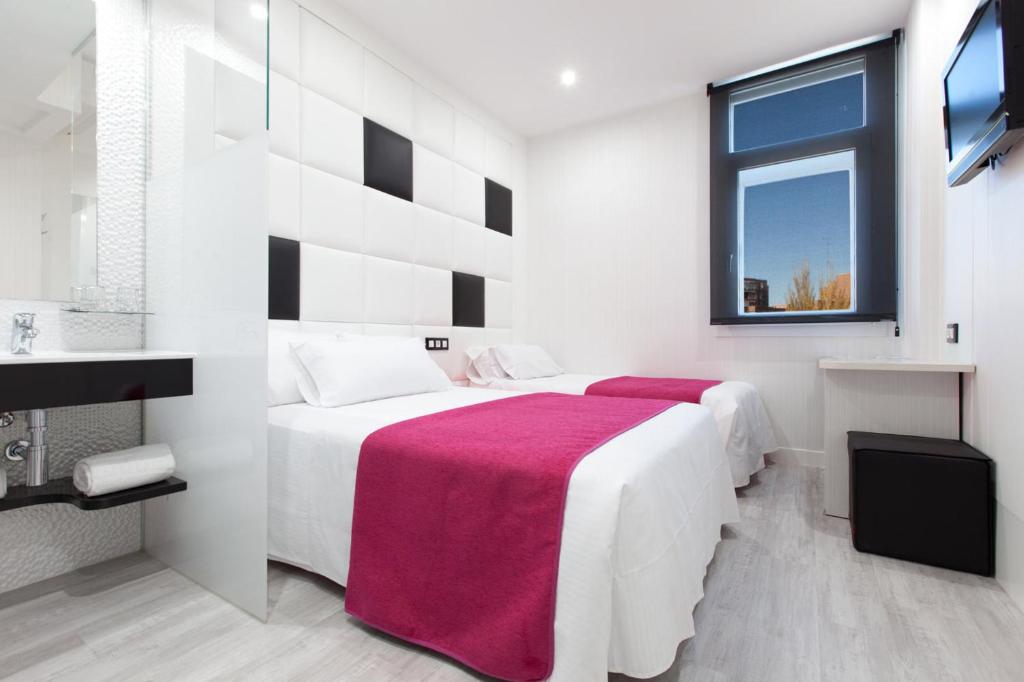 a white bedroom with a large bed with a red blanket at Hoteles Urbanos N Avenida de España in Fuenlabrada