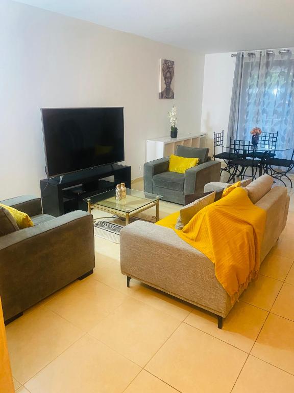 un salon avec deux canapés et une télévision à écran plat dans l'établissement Belle maison lumineuse, à Bailly-Romainvilliers