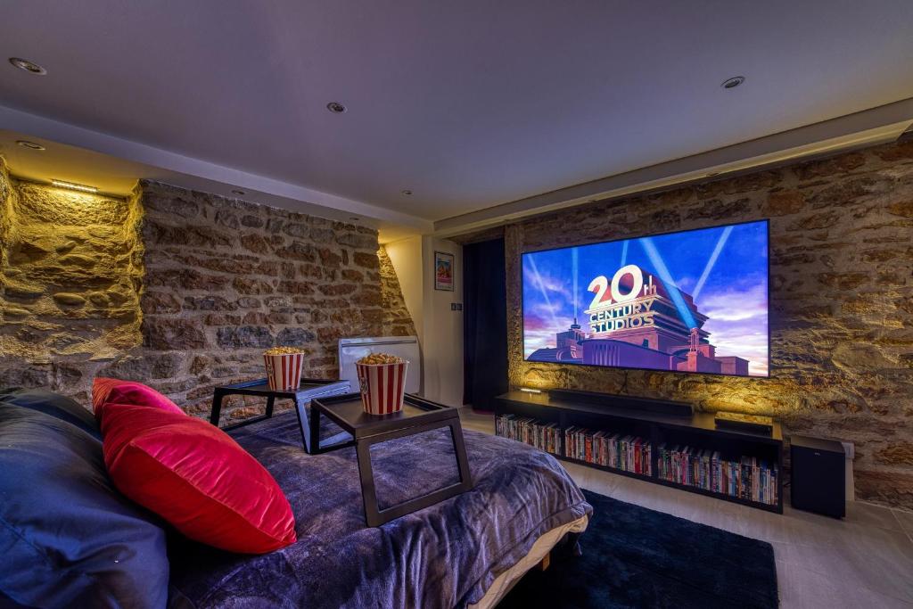 un salon avec un canapé et une télévision à écran plat dans l'établissement Movie Room Immersion unique et atmosphère cosy assurée, à Lyon