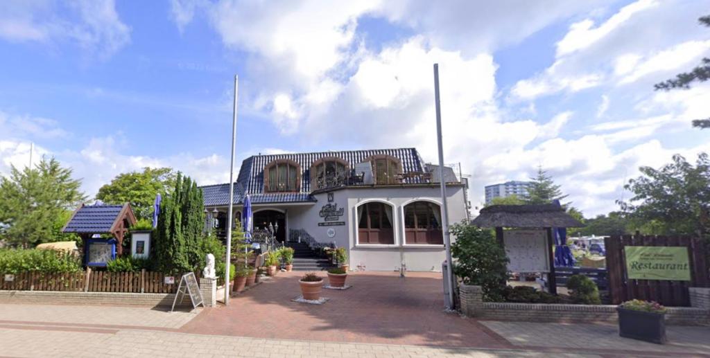 ein weißes Gebäude mit Balkon darüber in der Unterkunft Hotel Wernerwald in Cuxhaven