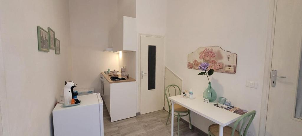 Habitación blanca con mesa y cocina pequeña en Casa Vacanze L'Ortensia, en Bagheria