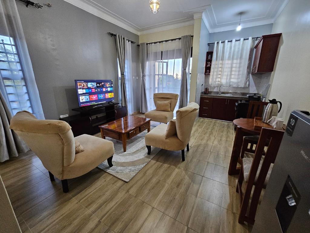 a living room with chairs and a flat screen tv at Orgonite SmartHomes in Kampala