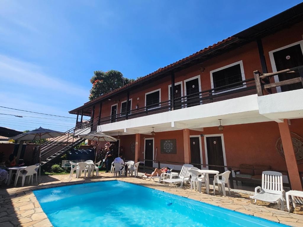 a swimming pool in front of a house at HOTELARE Pousada Bóra Morá in Ubatuba