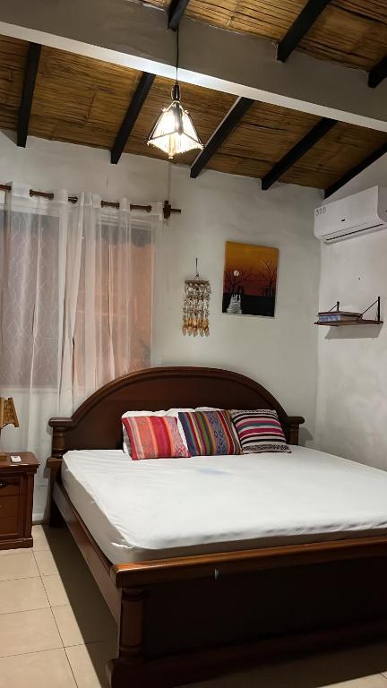 1 dormitorio con 1 cama grande con sábanas blancas en Cabaña Cangrejito Olon en Olón