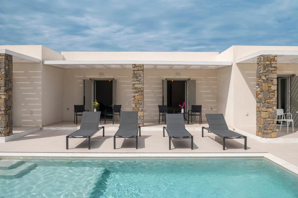 a patio with chairs and a swimming pool at Amouage Studios in Kampos Paros