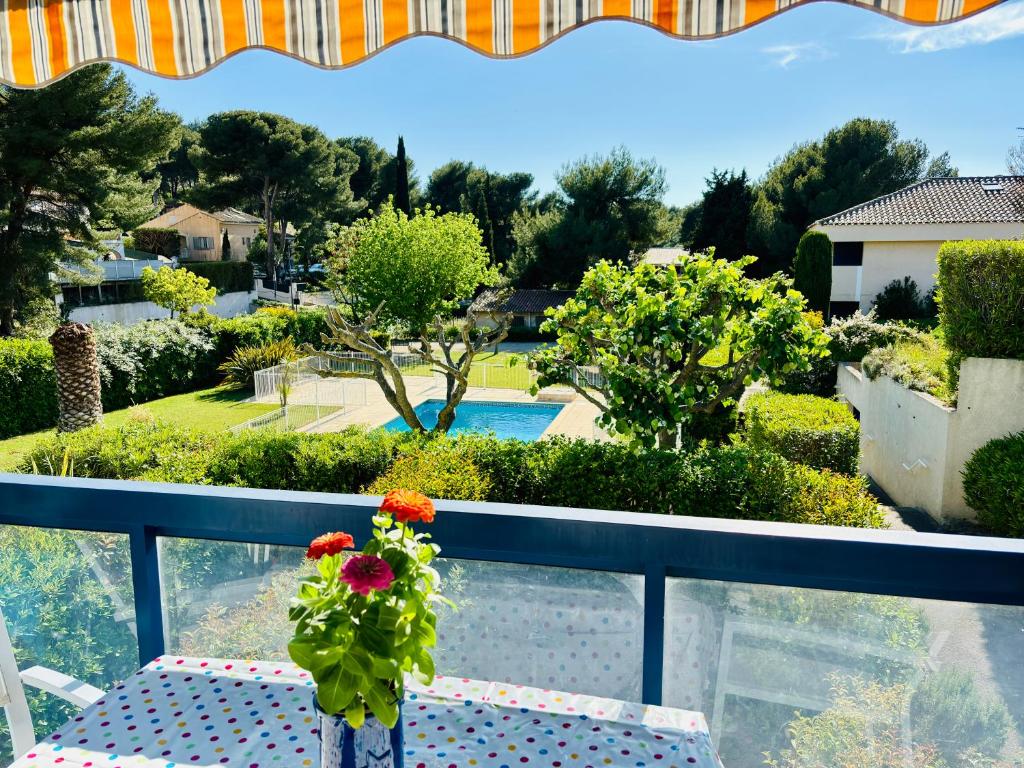 d'une table sur un balcon avec vue sur le jardin. dans l'établissement Chez mamie Paulette, Clim et Piscine, à 3 minutes à pied de la Plage, à Sanary-sur-Mer