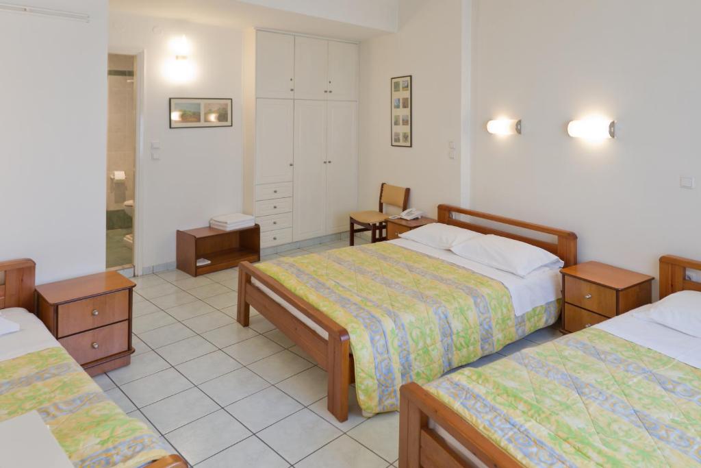 a hotel room with two beds and two tables at Alex Hotel in Tripolis