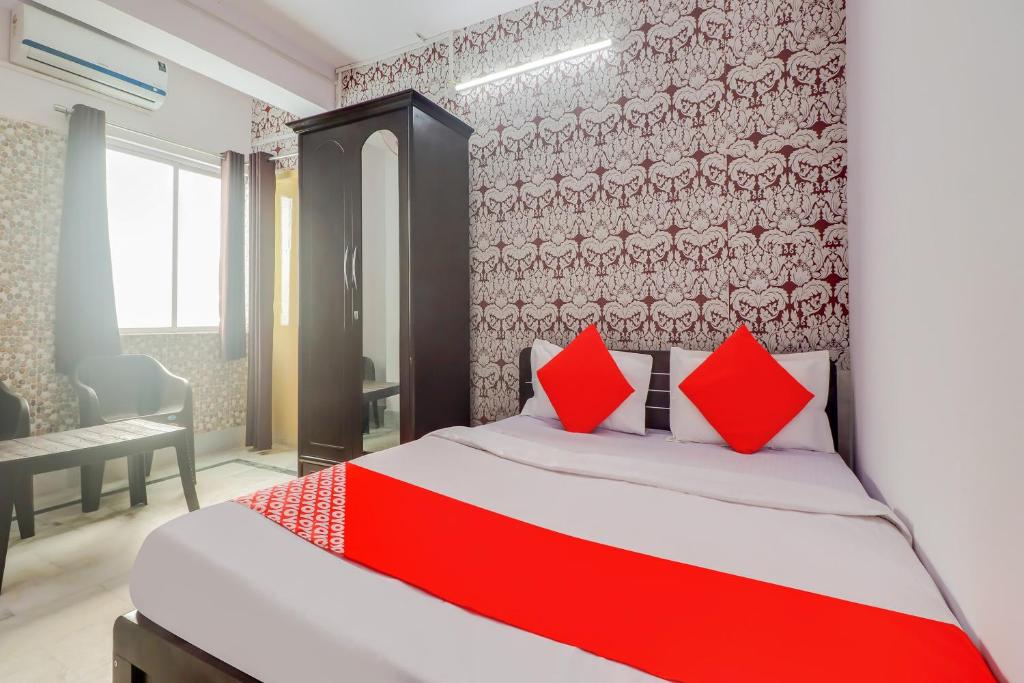 1 dormitorio con 1 cama con almohadas rojas en OYO Oxy Rudra Inn, en Ranchi