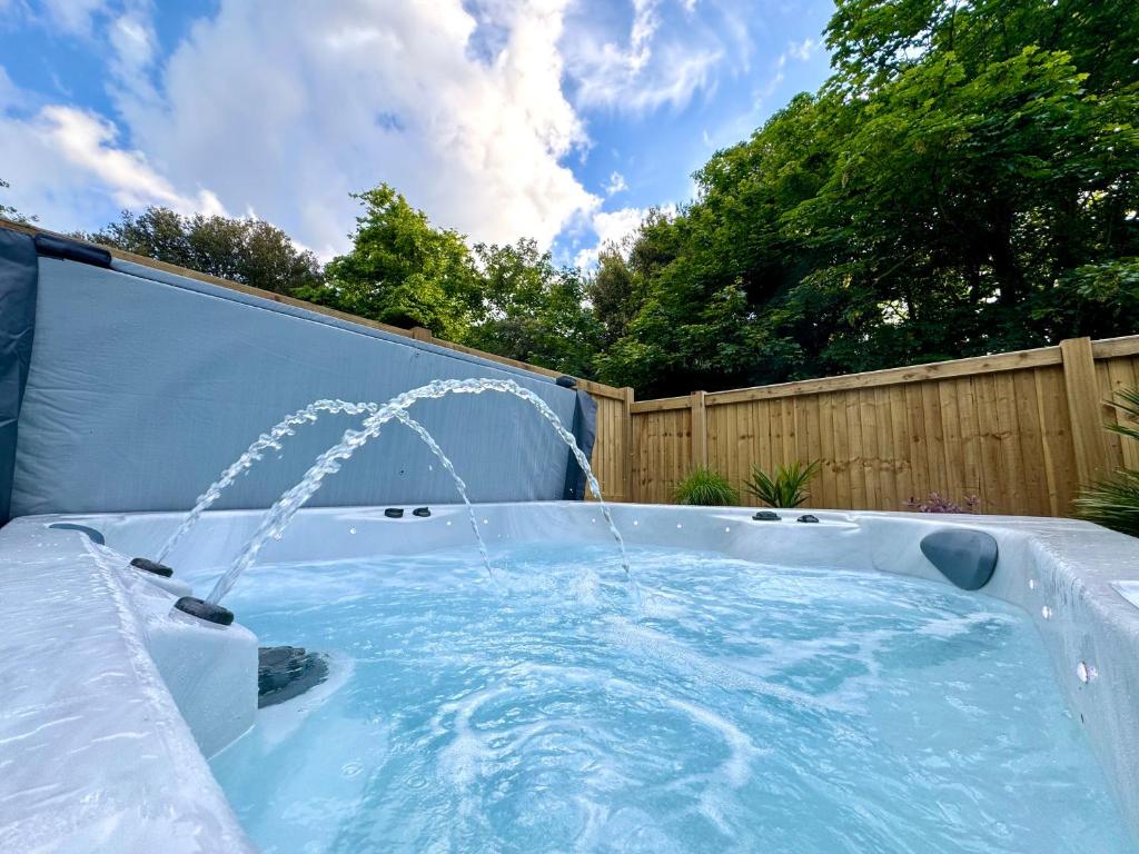 a hot tub with a water fountain in a backyard at North Lodge at Quex Park in Birchington