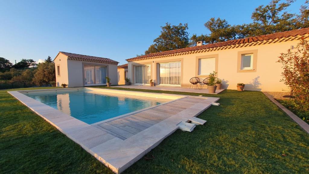a backyard with a swimming pool and a house at La Tiny de Louis, au milieu des oliviers, avec jolie piscine in Draguignan
