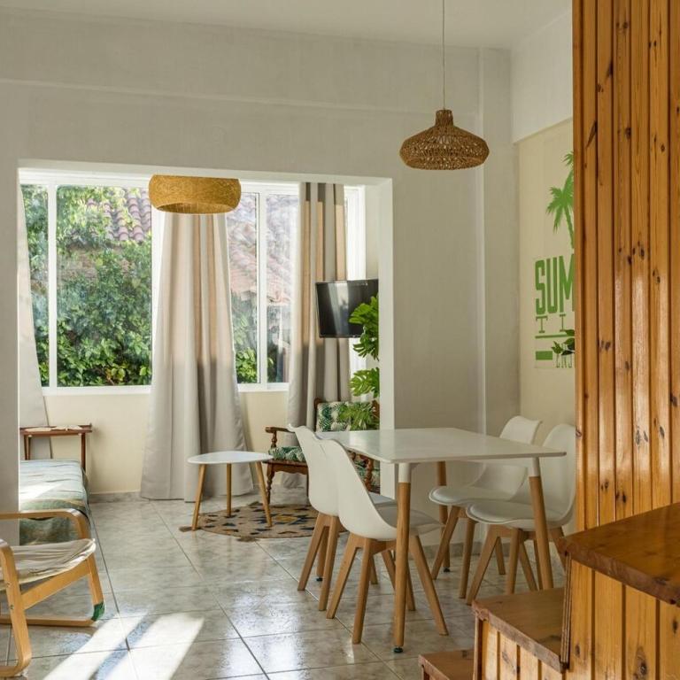 sala de estar con mesa y sillas en Maisonette with Palms, en Stoupa