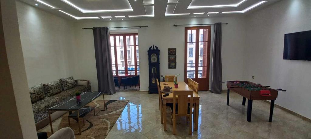 ein Wohnzimmer mit einem Sofa und einem Tisch in der Unterkunft Appartement Néoclassique centre-ville in Casablanca