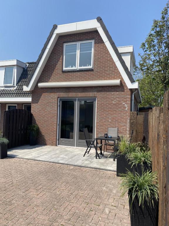 a brick house with a patio in front of it at Beach Dream 3C in Petten