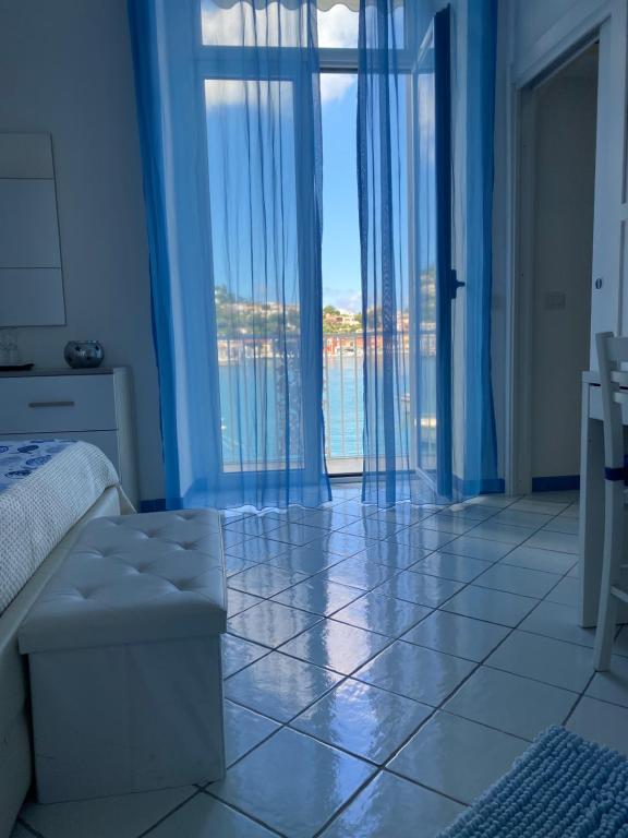 a bedroom with a large window with a view of the water at Riva Destra Suite apartament in Ischia