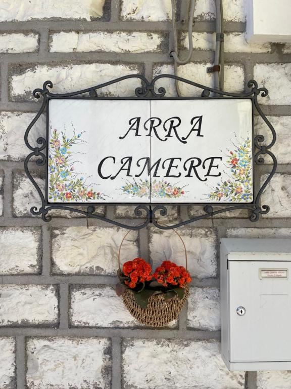ein Schild, das an einer Ziegelmauer hängt, mit Aaromakamera in der Unterkunft Arra Camere Sirolo - Rooms & Suite in Sirolo