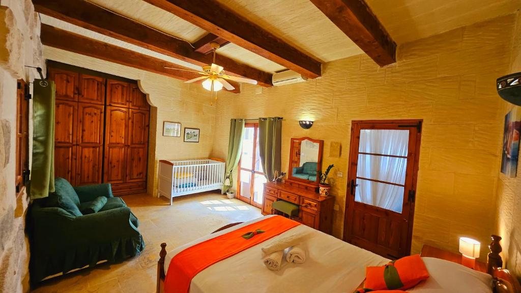 um quarto com uma cama e um sofá num quarto em Ta Katrin 3 Bedroom Farm House em Xaghra