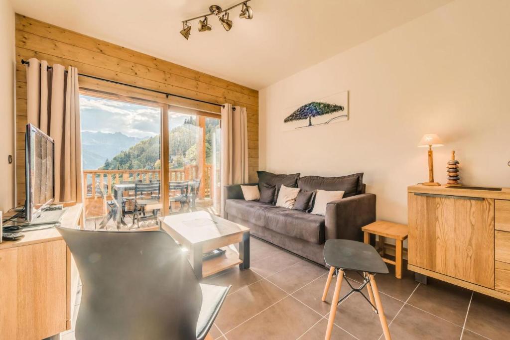 un salon avec un canapé et une grande fenêtre dans l'établissement Résidence Les Balcons EtoilÉs - Appartement 4 au pied des pistes MAE-3263, à Champagny-en-Vanoise