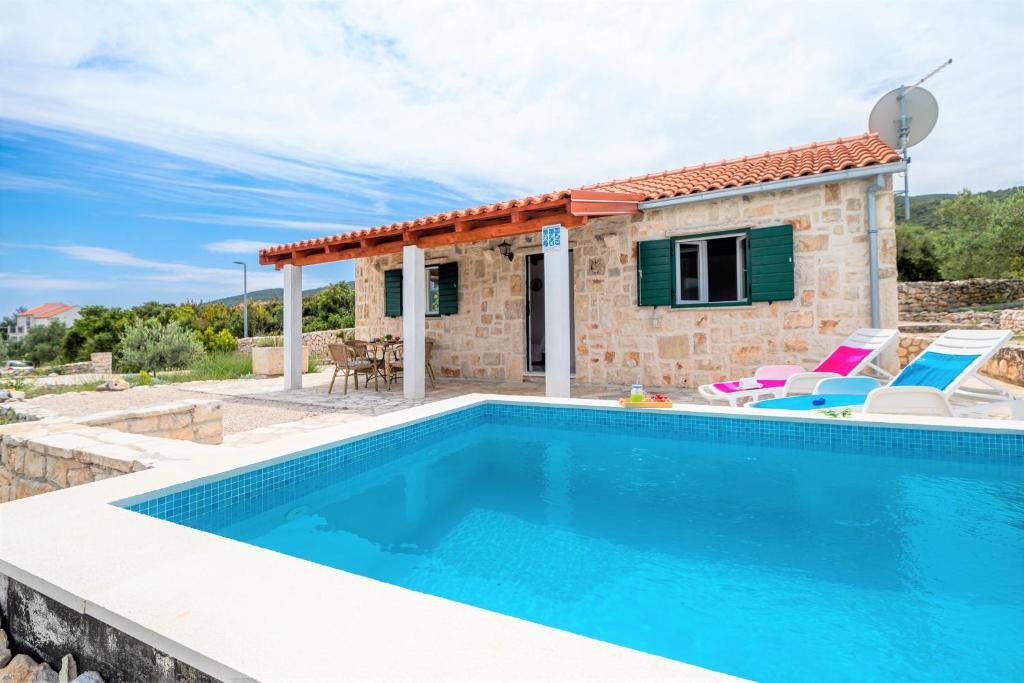 a villa with a pool in front of a house at Vineyard House & Olive Grove House in Račišće