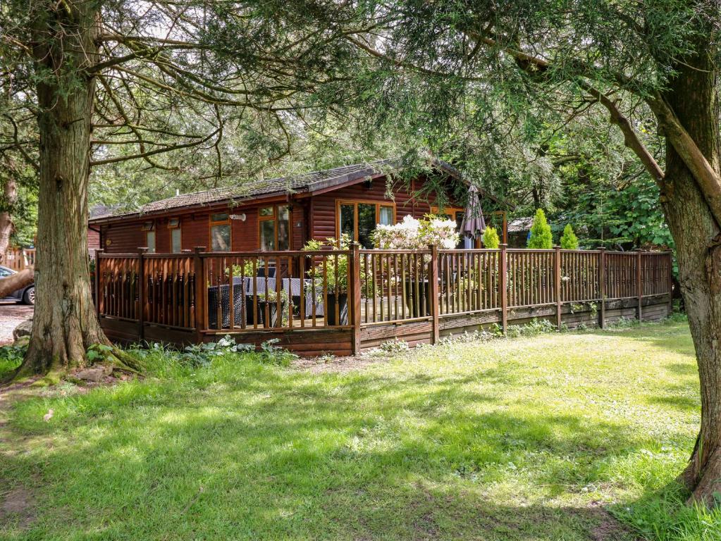 ウィンダミアにあるFootprints Lodgeの柵付きの庭の木造小屋