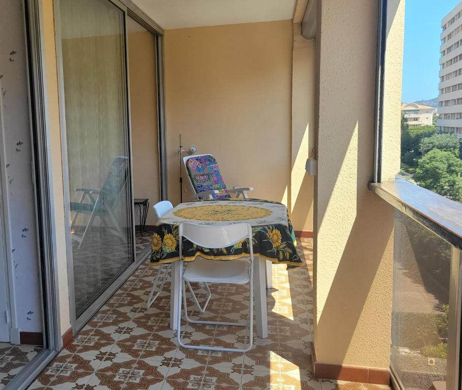 Elle comprend un balcon avec une table et deux chaises. dans l'établissement Bright seafront apartment, à Fréjus
