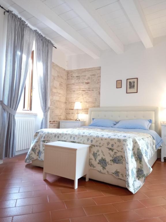 Habitación blanca con cama y ventana en La Cialdina - La CONCHIGLIA Sirolo Apartment, en Sirolo