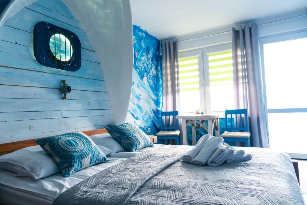 - une chambre dotée d'un lit avec un mur bleu dans l'établissement K 2, à Jastrzębia Góra