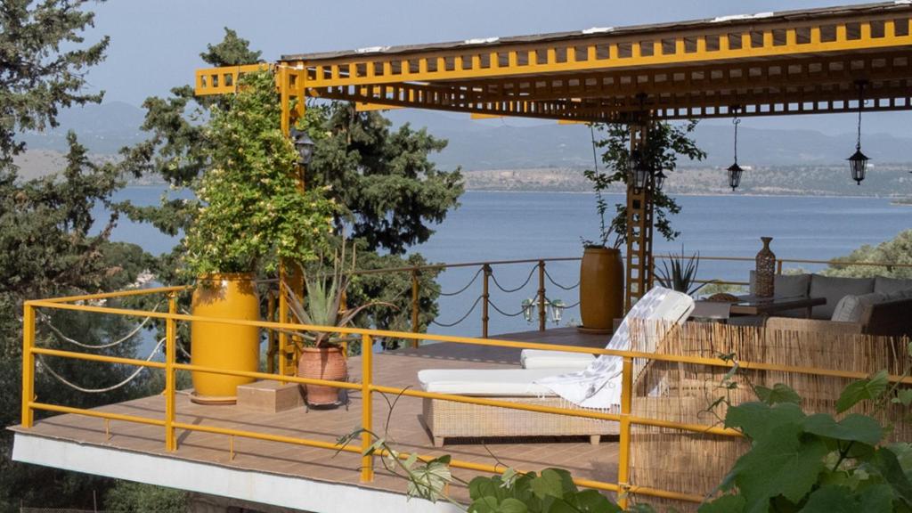 una ringhiera gialla su un ponte con vista sull'acqua di Country House Hortensia a Spartos