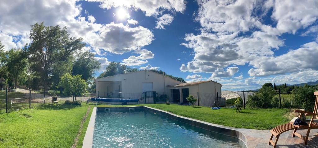 une piscine dans une cour avec un bâtiment et une maison dans l'établissement Maison au pied du mont ventoux, à Carpentras